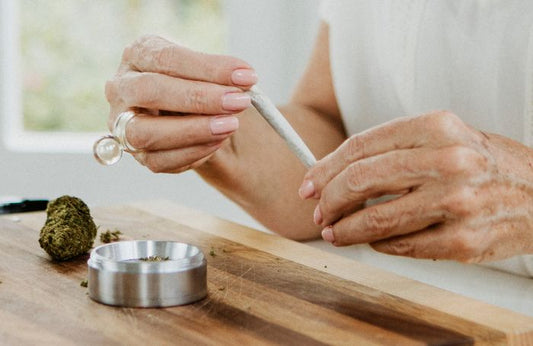 Senior ținând un joint de marijuana