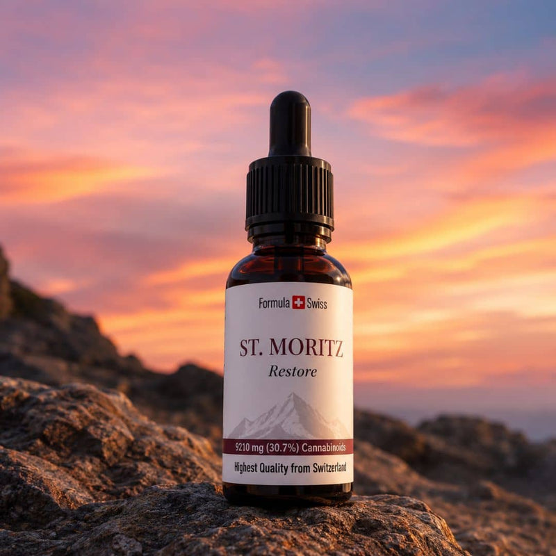 Flaconul de ulei CBD Formula Swiss St. Moritz Restore, expus pe stânci de munte, sub un cer de apus intens.