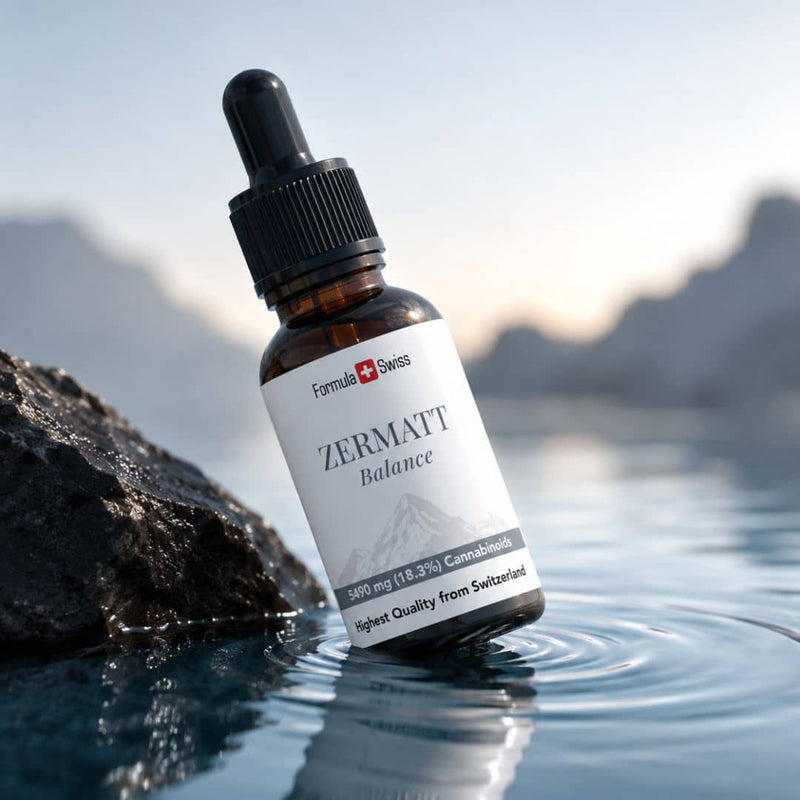 Flaconul cu ulei de canabinoizi Formula Swiss Zermatt Balance, expus lângă o stâncă, în apă limpede, pe fundalul unui peisaj montan elvețian.